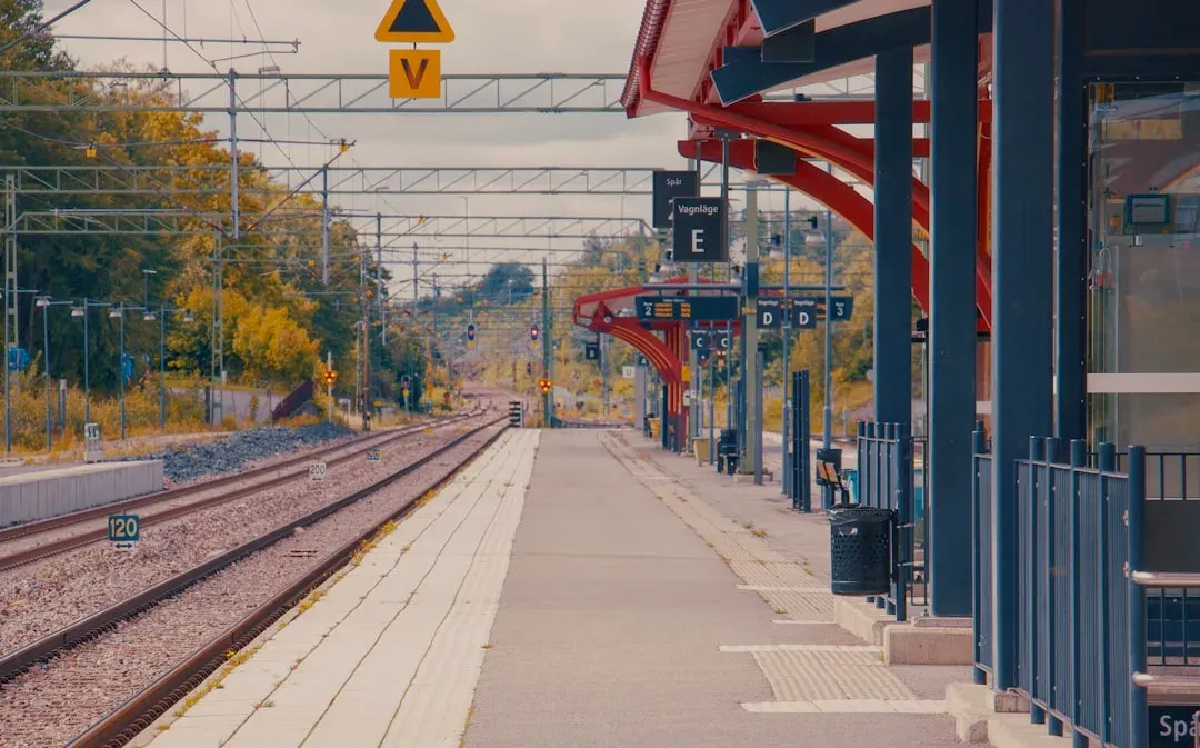 modern train station platform with departures board and luggage